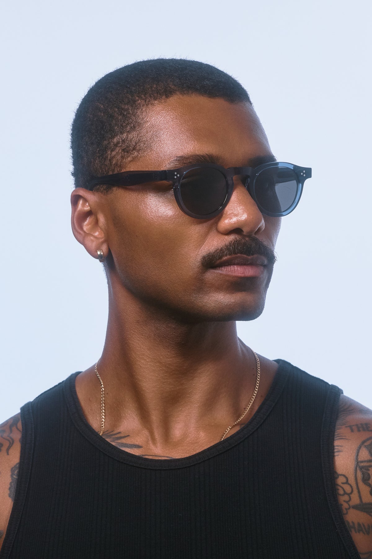 Side profile of a male model wearing Isle of Eden Drew Blue Prescription unisex bio aacetate sunglasses.