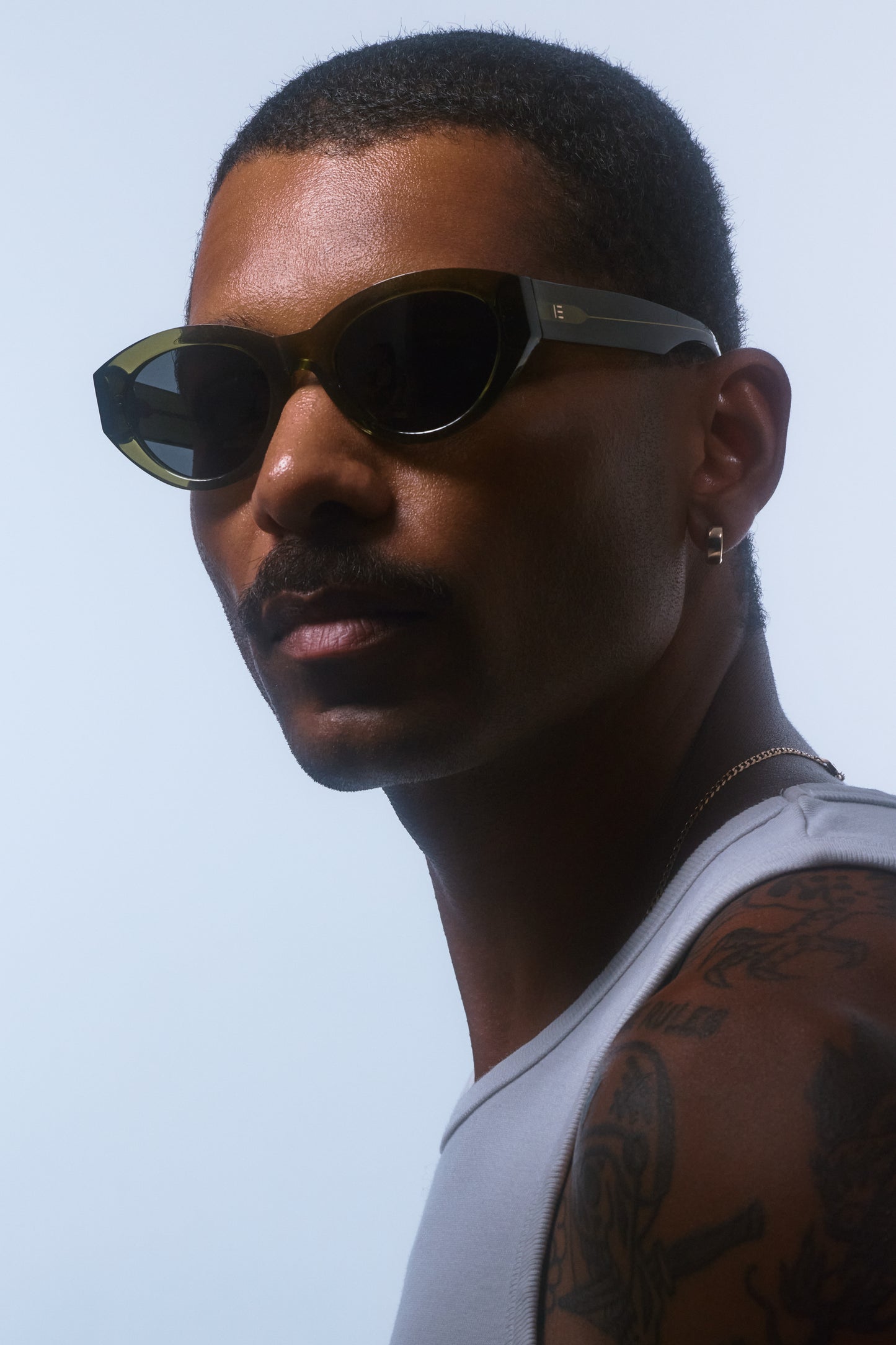 Male model wearing Isle of Eden Felina frosted green sunglasses, angled portrait