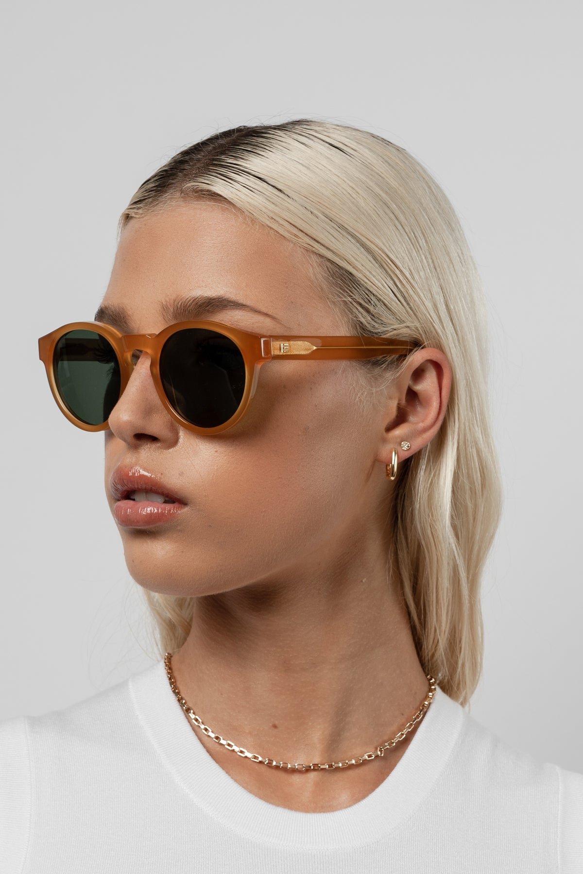 Female model wearing Isle of Eden Eddie yellow sunglasses, angled portrait