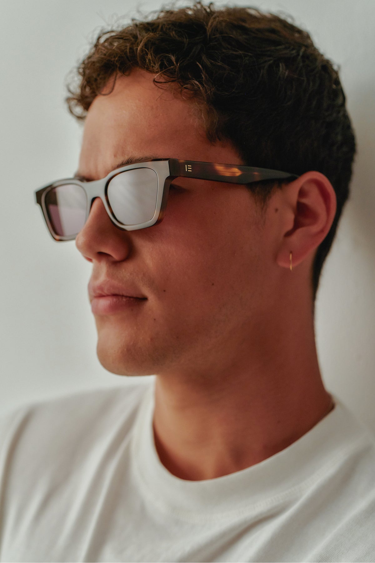 Male model wearing Isle of Eden Brooklyn tortoise sunglasses, angled side profile portrait