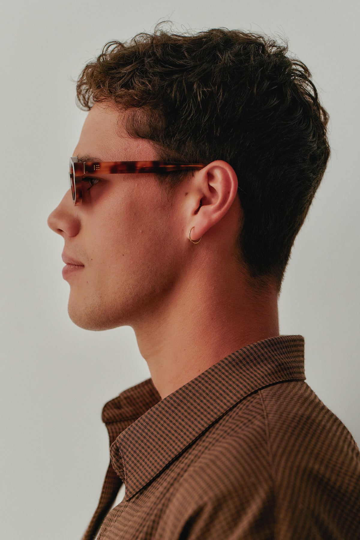 Male model wearing Isle of Eden Luca tortoise sunglasses, side profile portrait