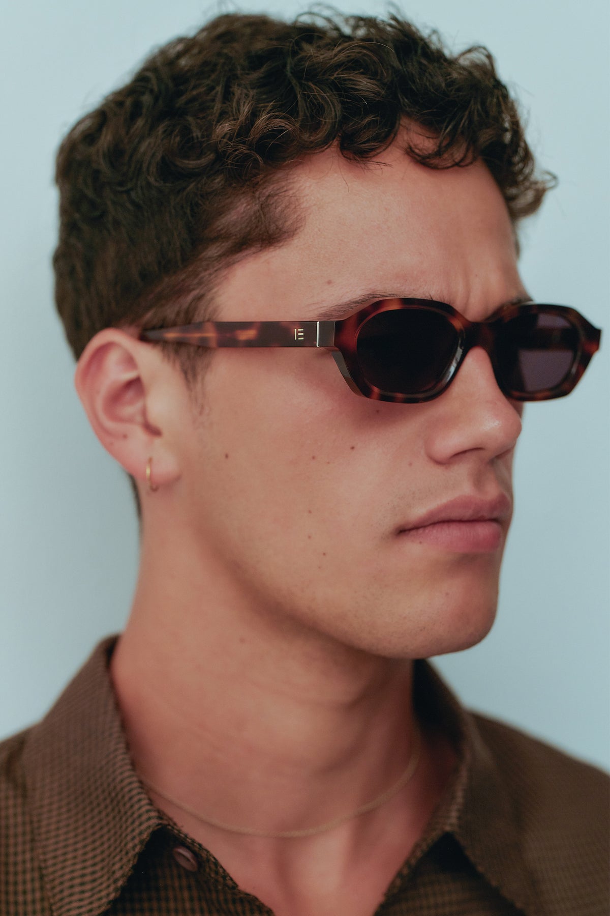 Male model wearing Isle of Eden Luca tortoise sunglasses, angled portrait looking away