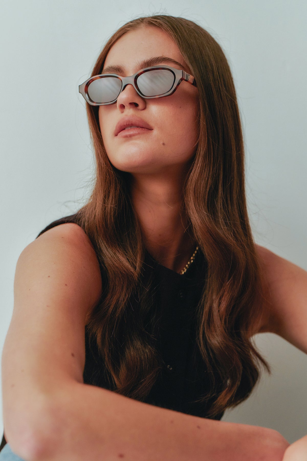 Female model wearing Isle of Eden Luca tortoise sunglasses, angled portrait looking away