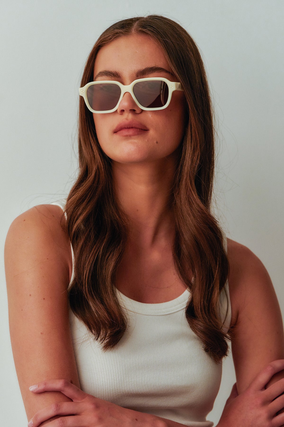 Female model wearing Isle of Eden Jamie ivory sunglasses, angled portrait looking away