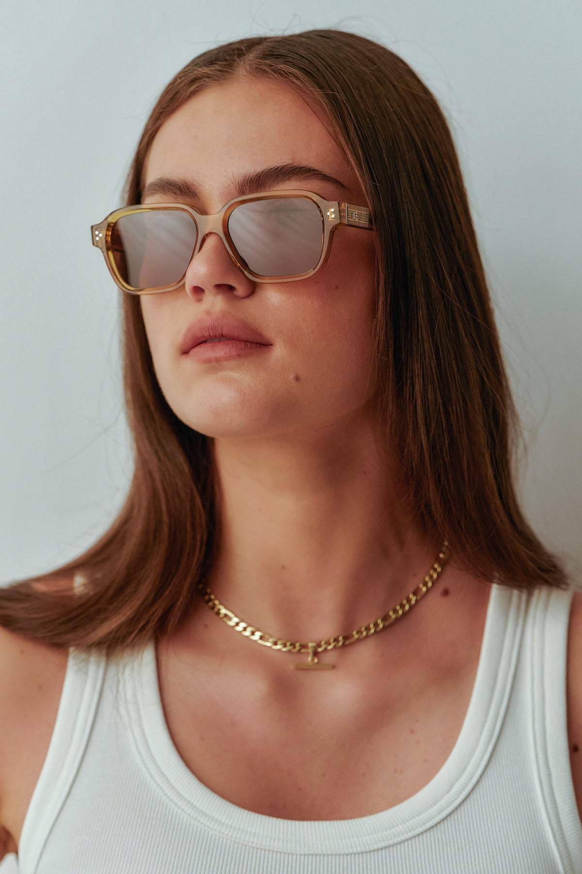 Female model wearing Isle of Eden Jamie cognac sunglasses, angled portrait looking away