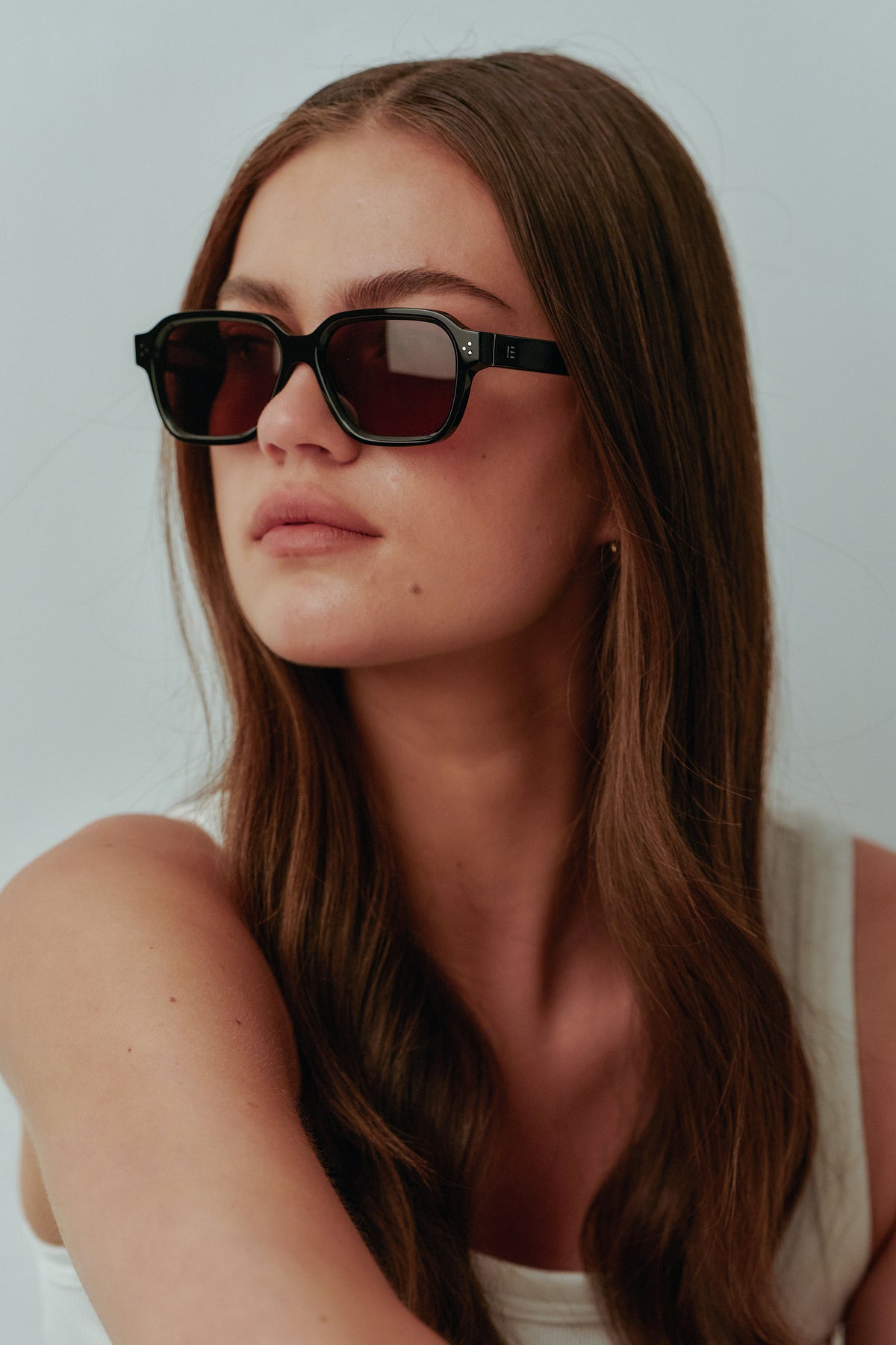 Female model wearing Isle of Eden Jamie black sunglasses, angled portrait looking away