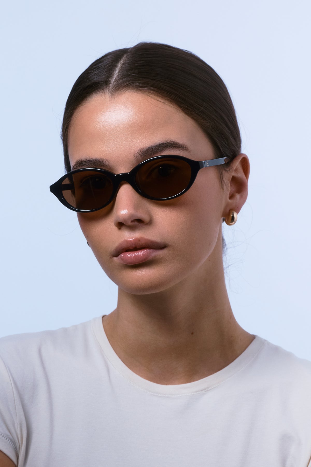 Female model wearing Isle of Eden Mirabel black sunglasses, front-facing portrait looking directly at the camera