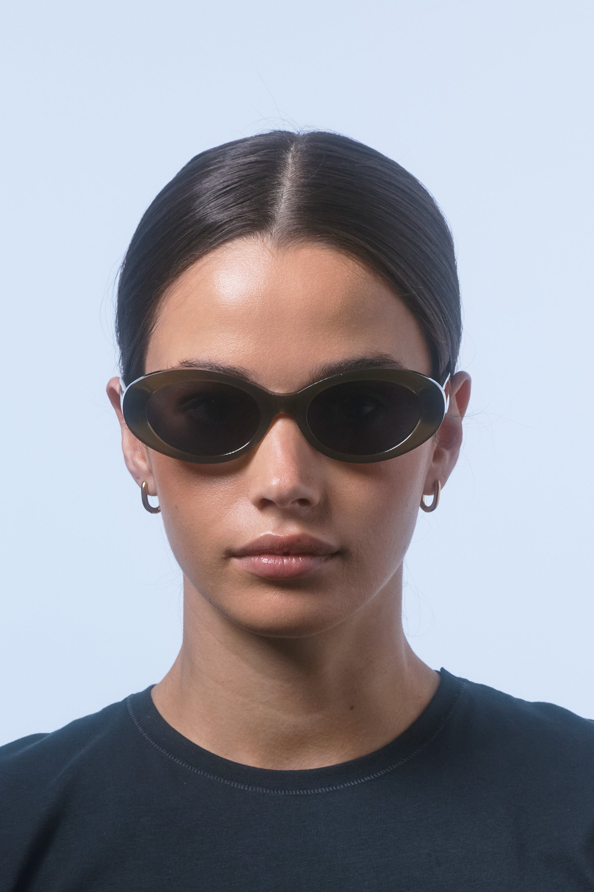 Female model wearing Isle of Eden Frankie frosted green sunglasses, close front-facing portrait