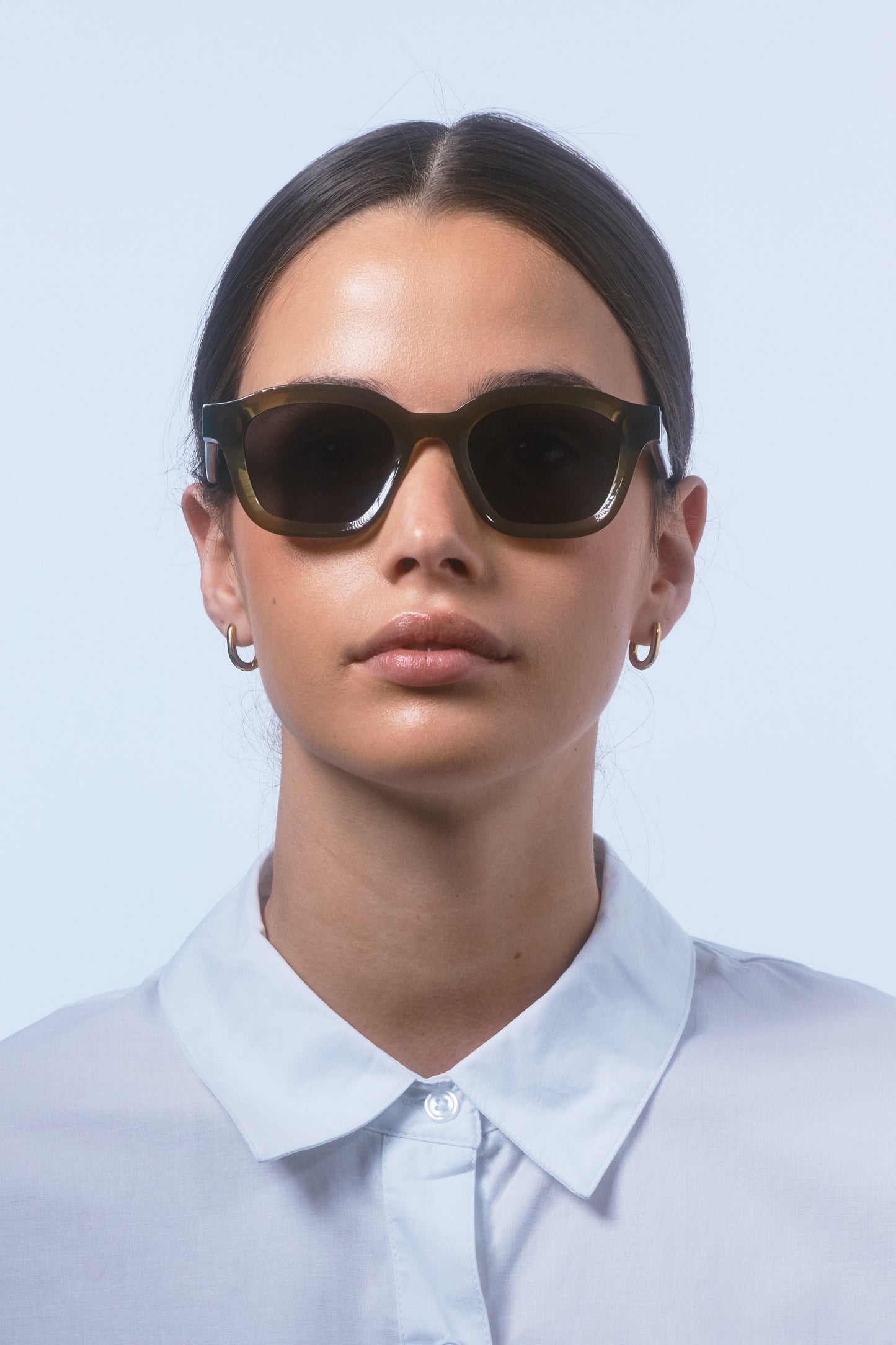 Female model wearing Isle of Eden Harley frosted green sunglasses, front-facing portrait