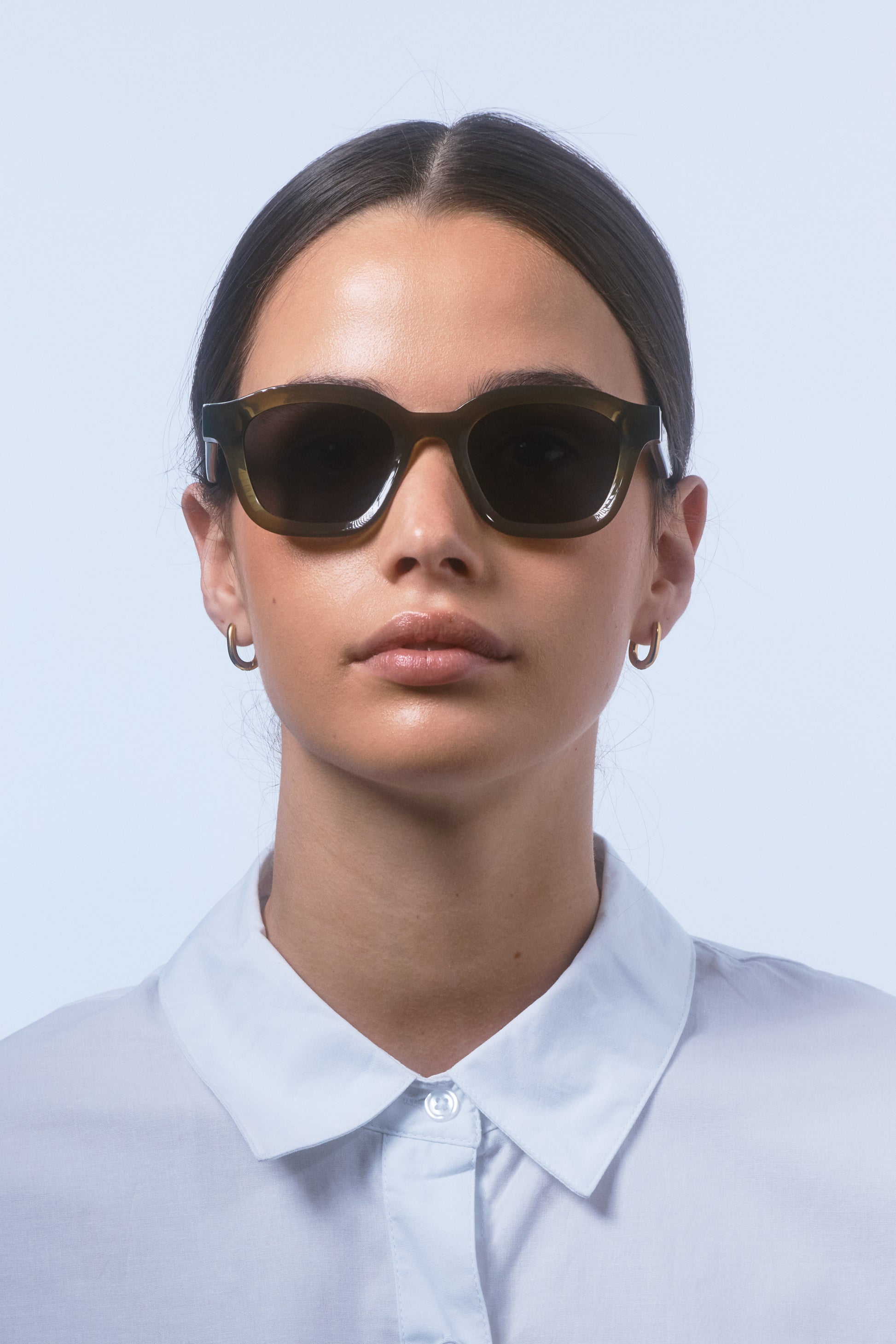 Female model wearing Isle of Eden Harley frosted green sunglasses, front-facing portrait