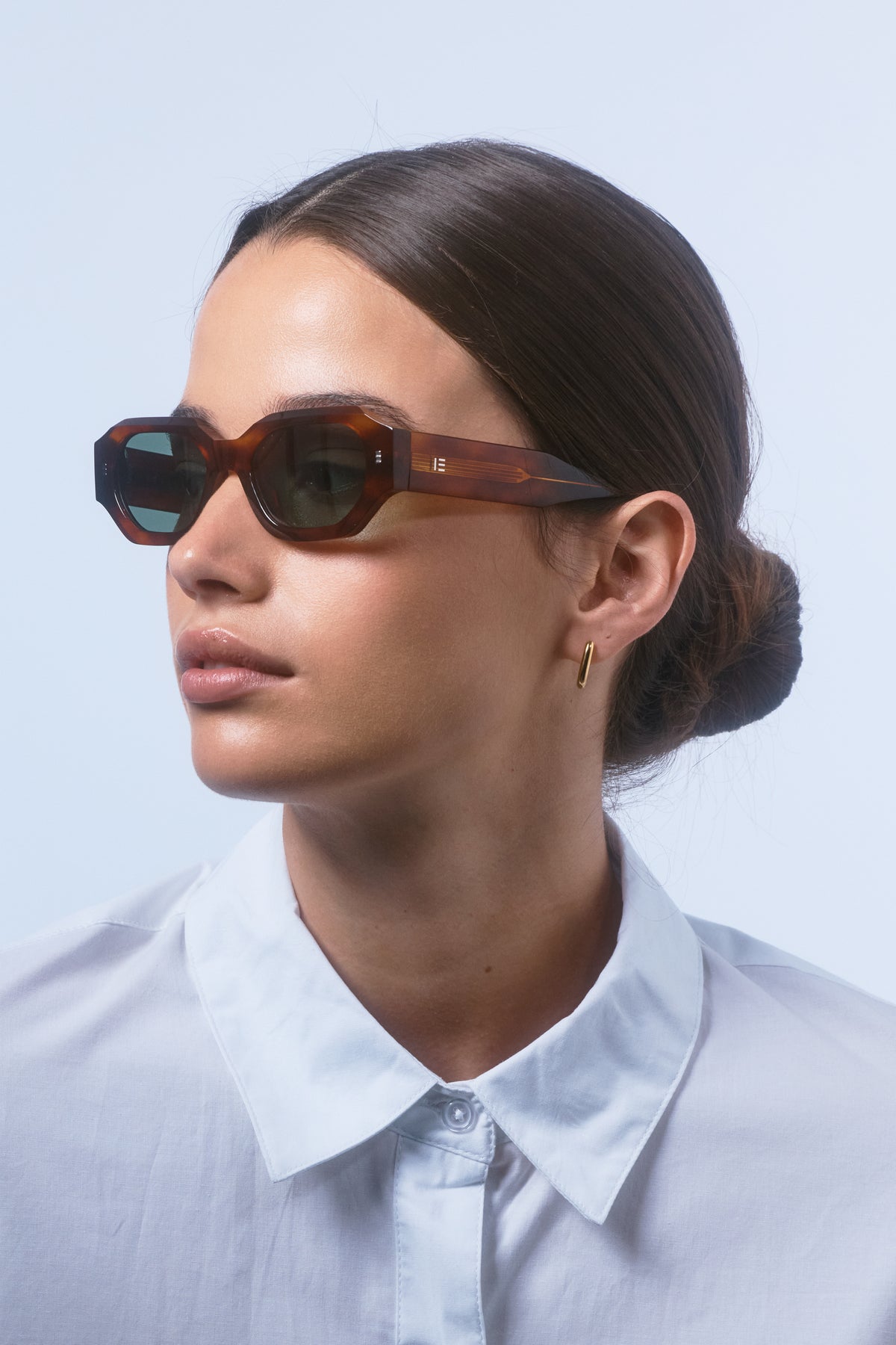 Model wearing Isle of Eden Blake honey tortoise sunglasses, angled side profile showing hexagonal frame and temple arm
