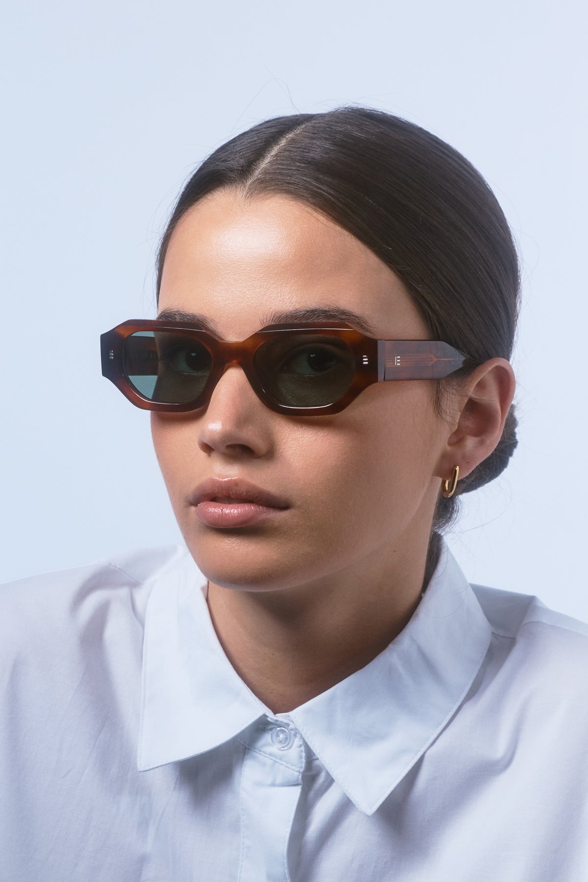 Model wearing Isle of Eden Blake honey tortoise sunglasses, front-facing portrait showing hexagonal frame fit