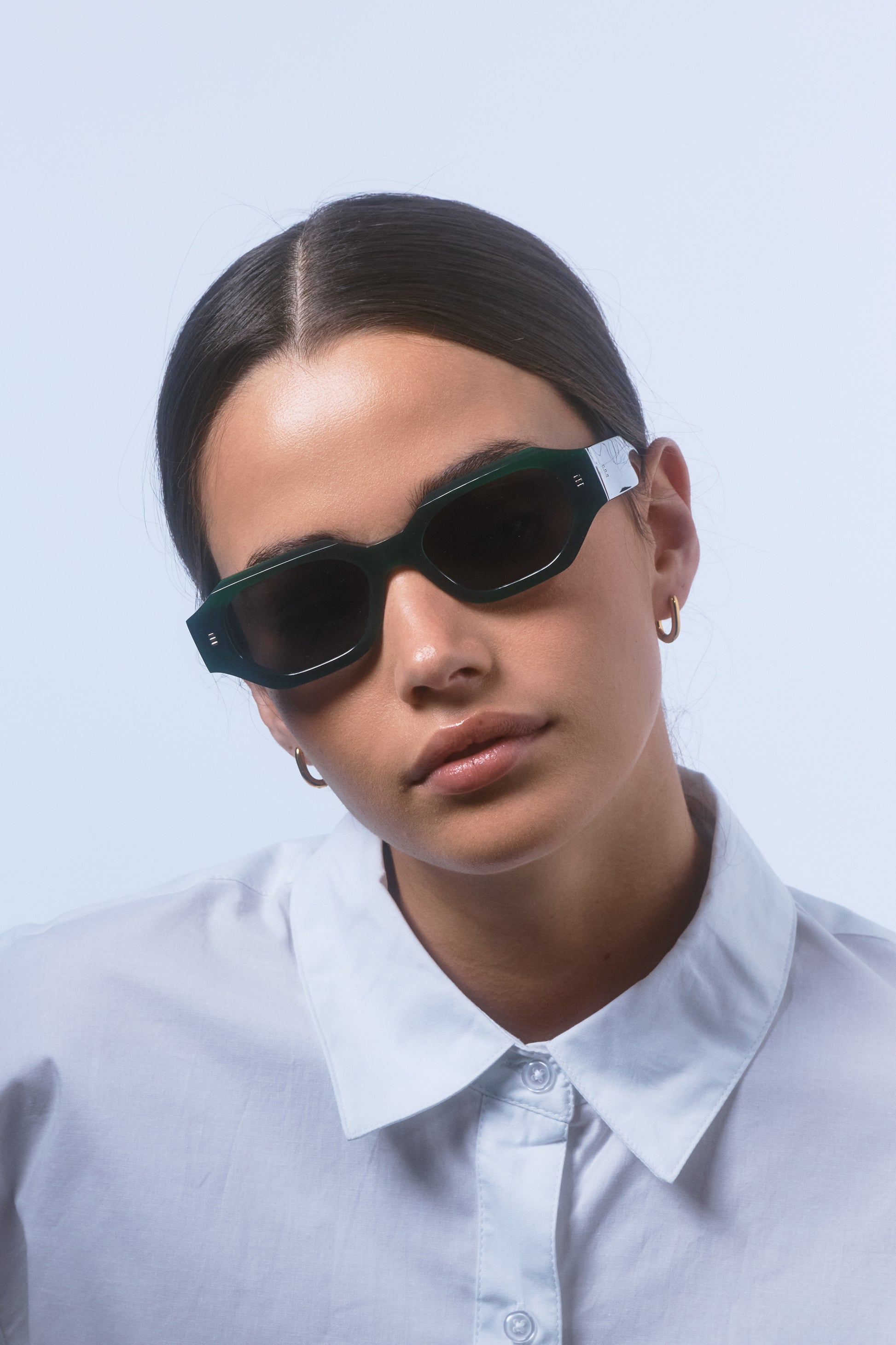 Model wearing Isle of Eden Blake emerald sunglasses, angled side profile showing hexagonal frame and temple arm