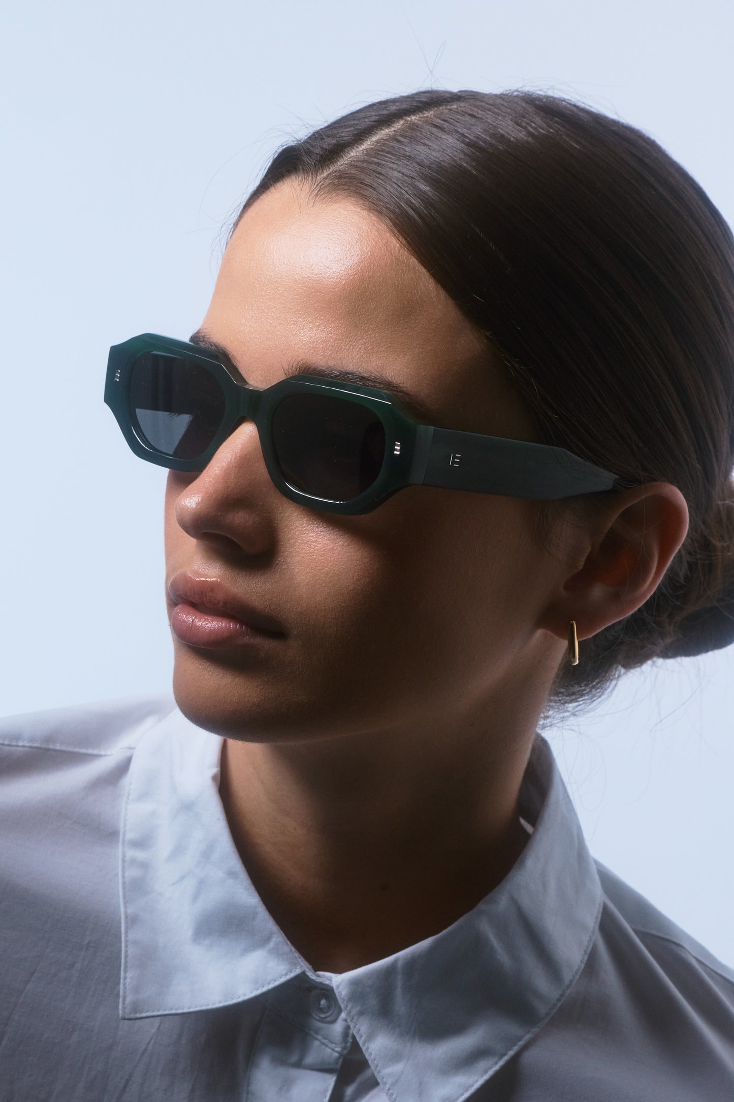 Model wearing Isle of Eden Blake emerald sunglasses, three-quarter angled portrait looking away from camera