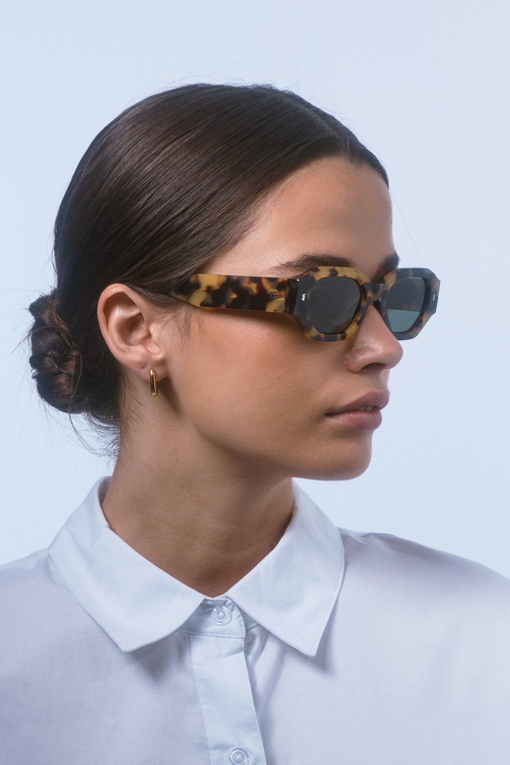 Model wearing Isle of Eden Blake tortoise sunglasses, angled side profile showing hexagonal frame and temple arm