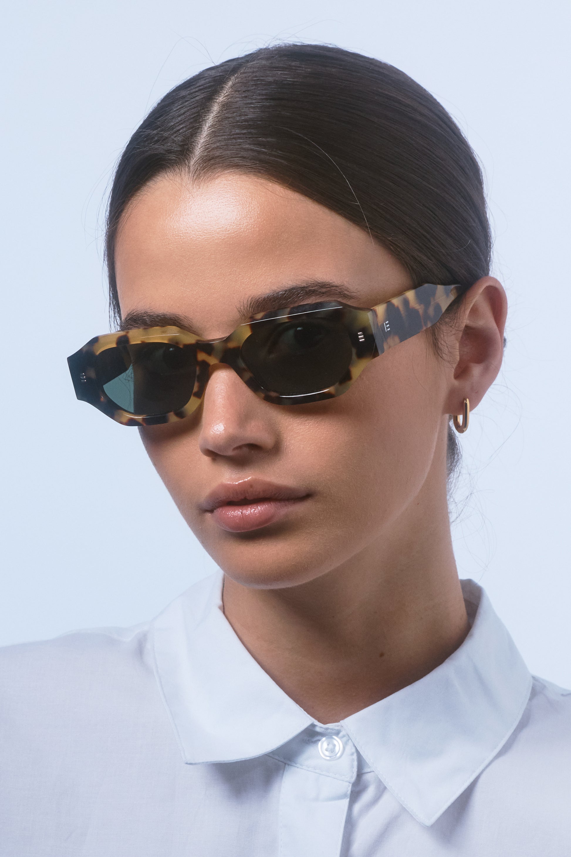 Model wearing Isle of Eden Blake tortoise sunglasses, close portrait showing hexagonal frame fit