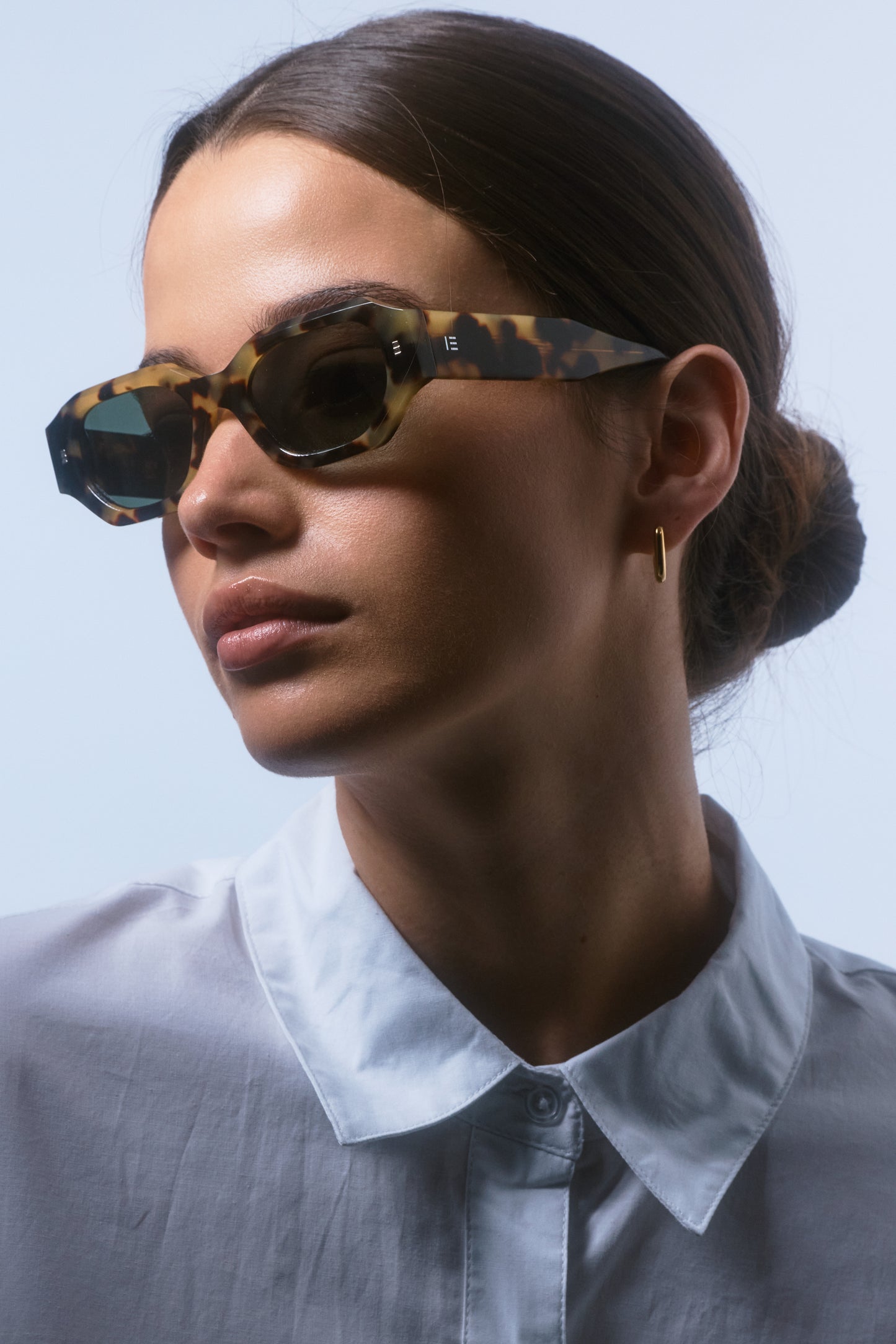 Model wearing Isle of Eden Blake tortoise sunglasses, angled portrait showing brand lettering on temple