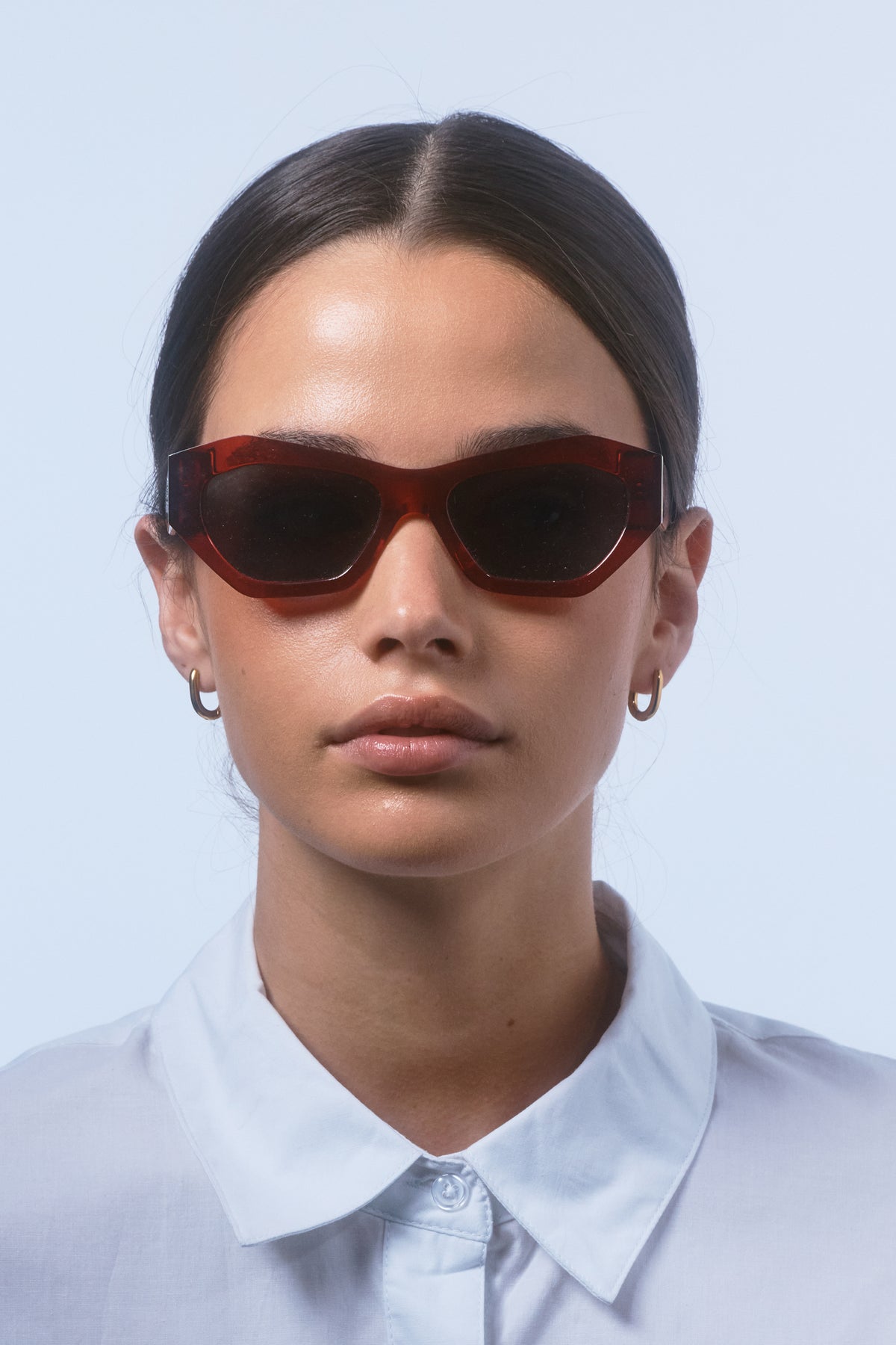 Female model wearing Isle of Eden Emily red sunglasses, portrait looking directly at the camera