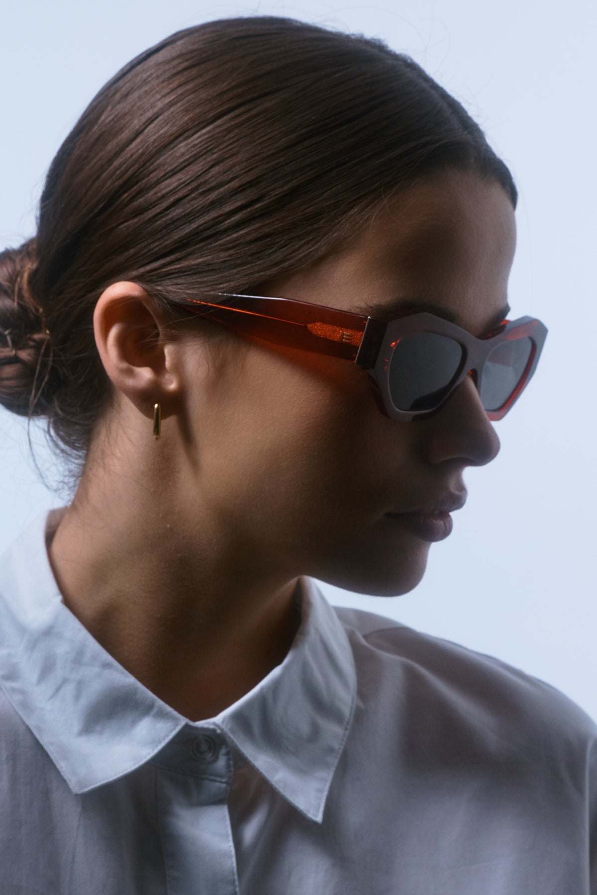 Female model wearing Isle of Eden Emily red sunglasses, side profile portrait