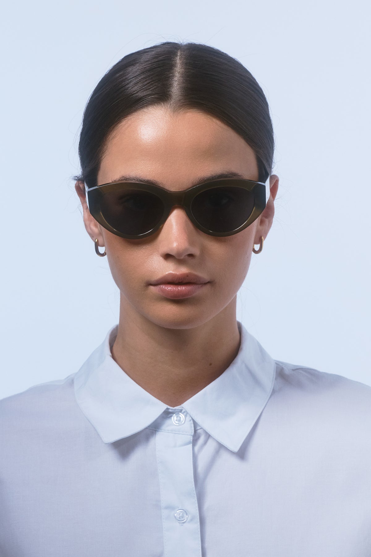 Female model wearing Isle of Eden Felina frosted green sunglasses, front-facing portrait looking directly at the camera