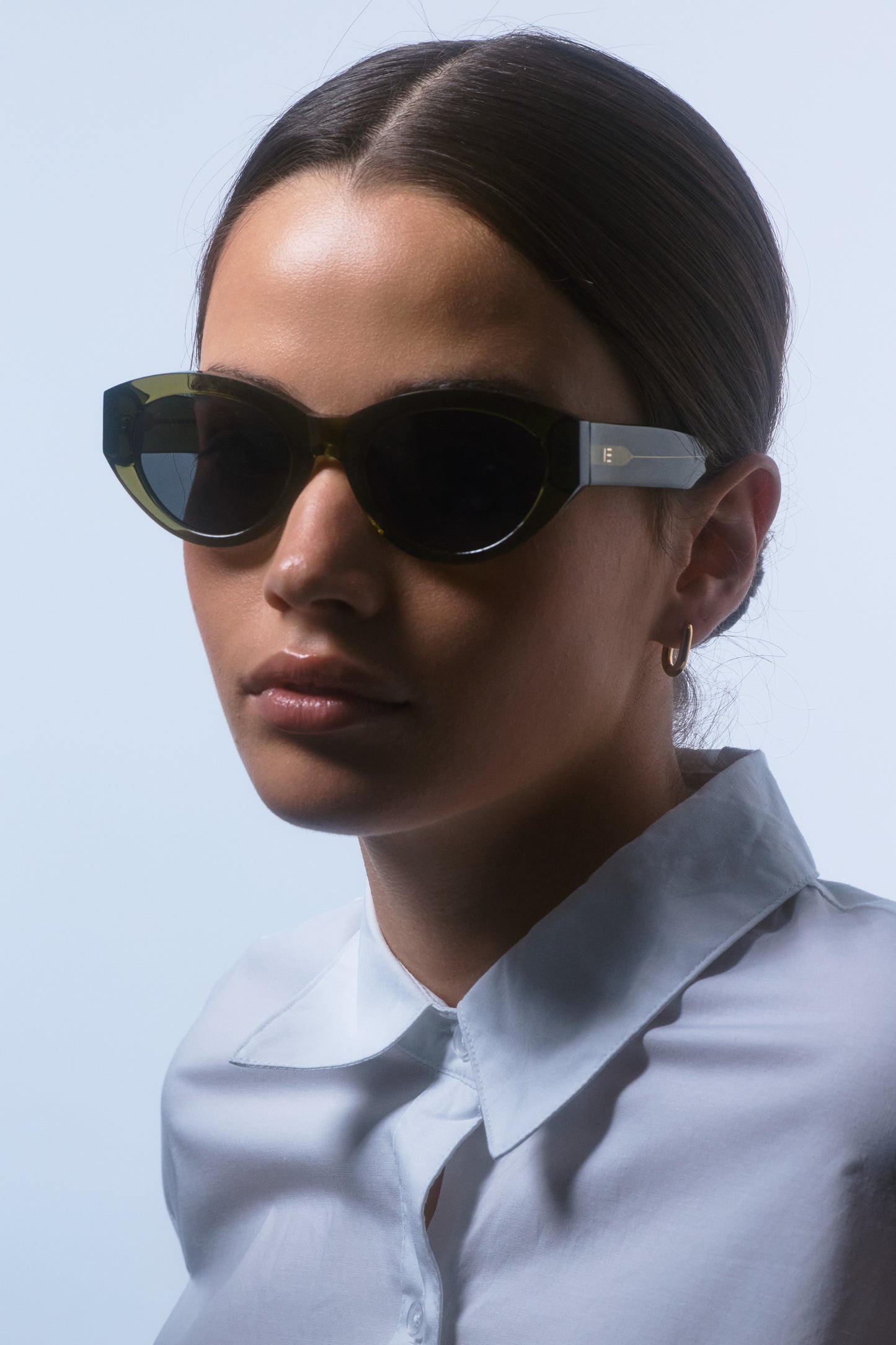 Female model wearing Isle of Eden Felina frosted green sunglasses, angled portrait