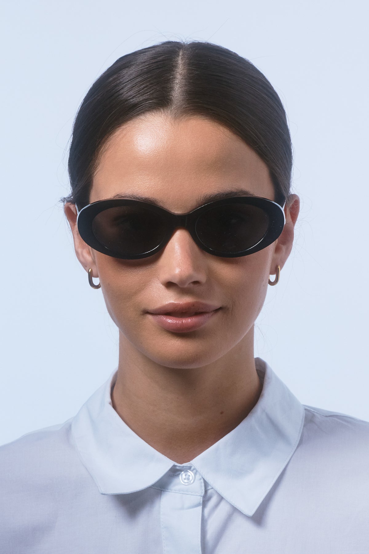 Female model wearing Isle of Eden Frankie black sunglasses, front-facing portrait looking directly at the camera