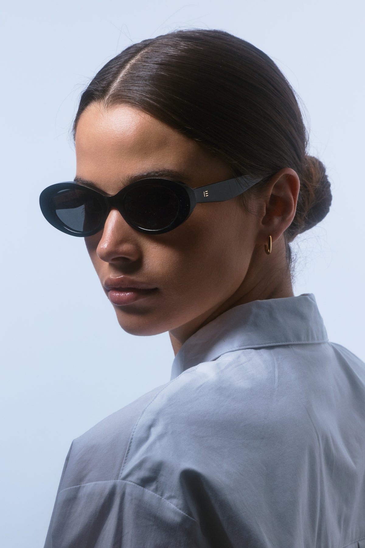 Female model wearing Isle of Eden Frankie black sunglasses, side profile portrait