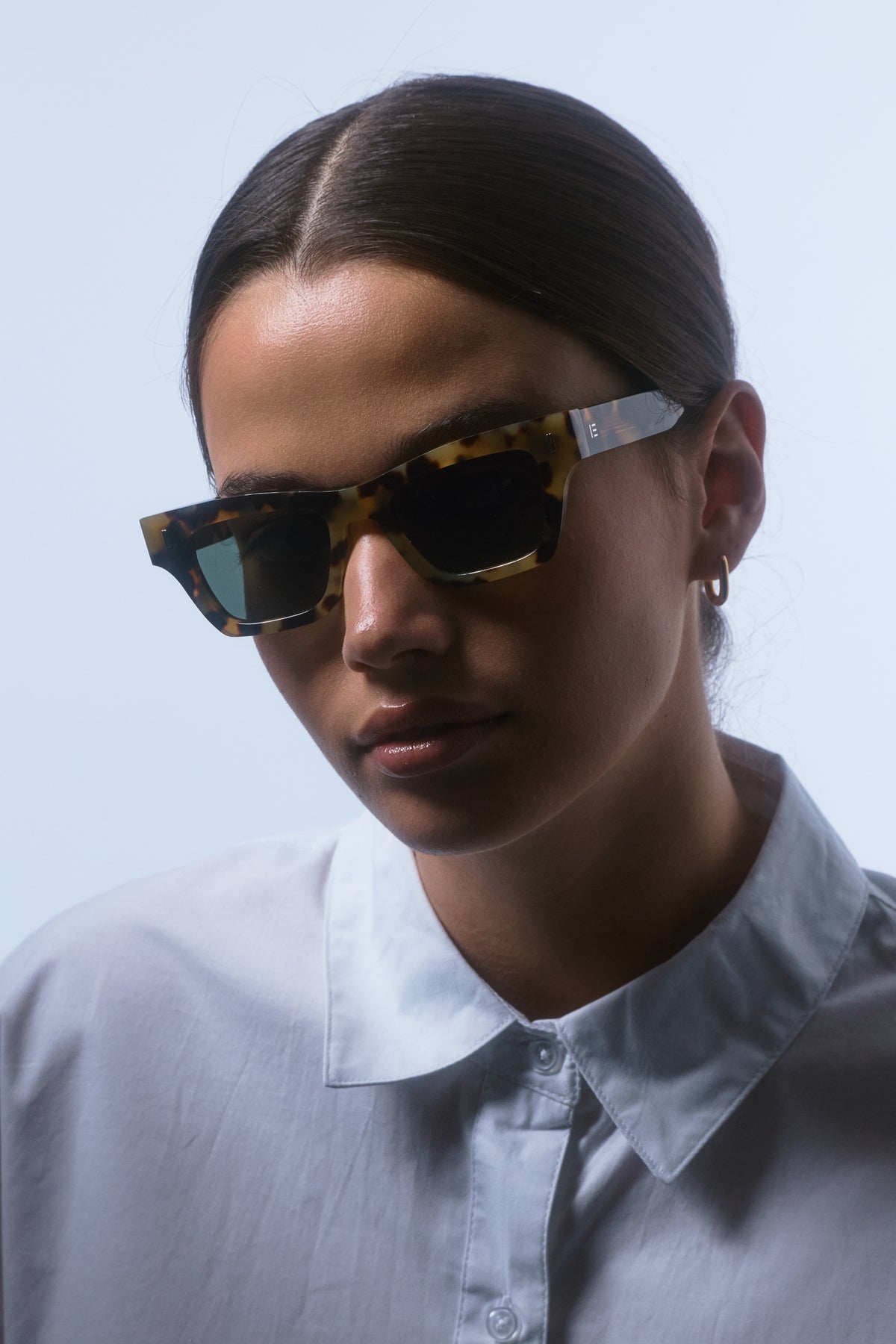 Female model wearing Isle of Eden Olli tortoise sunglasses, front-facing portrait looking directly at the camera