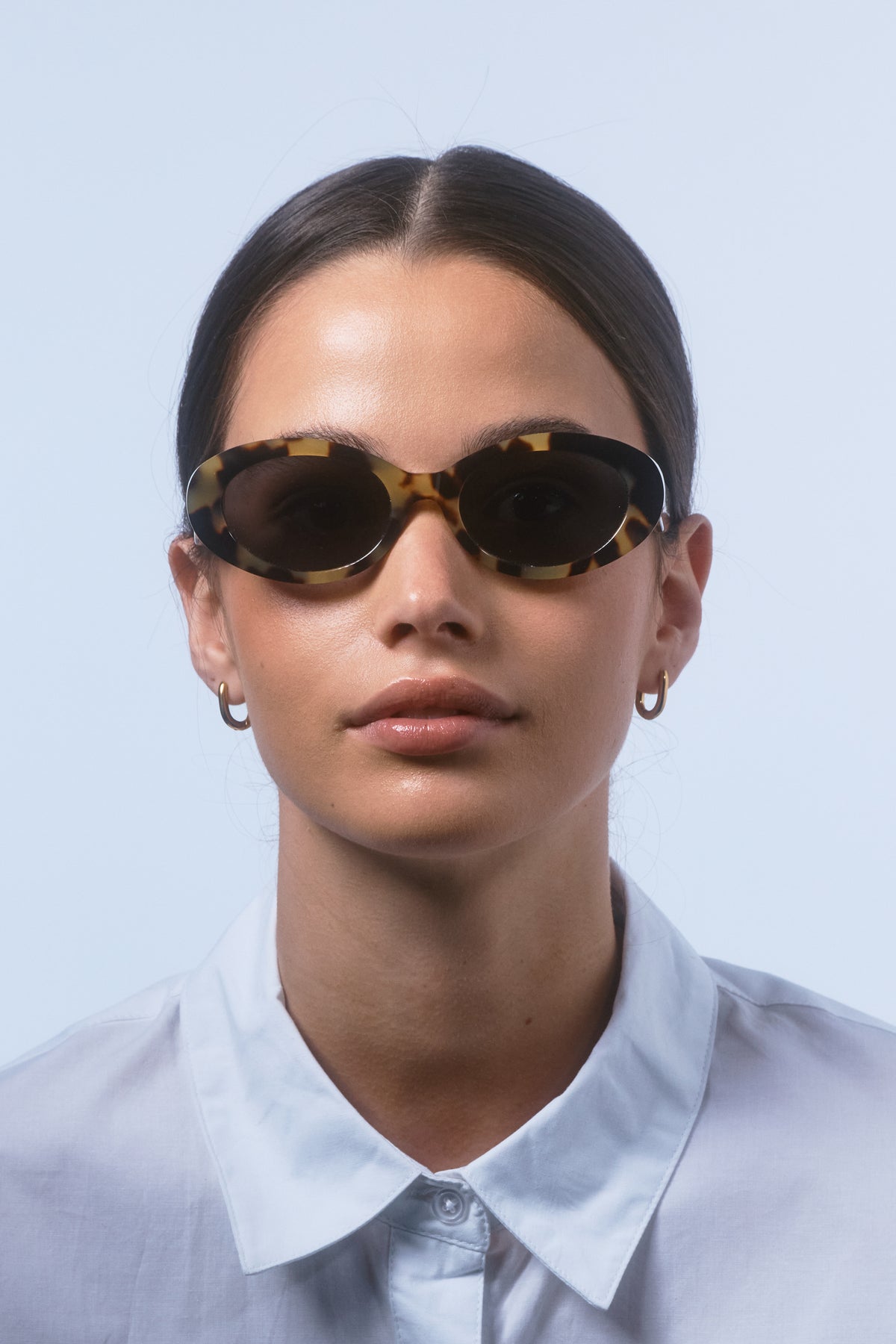 Female model wearing Isle of Eden Frankie tortoise sunglasses, front-facing portrait looking directly at the camera