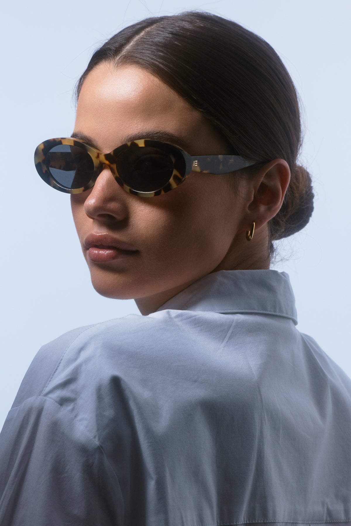 Female model wearing Isle of Eden Frankie tortoise sunglasses, side profile portrait