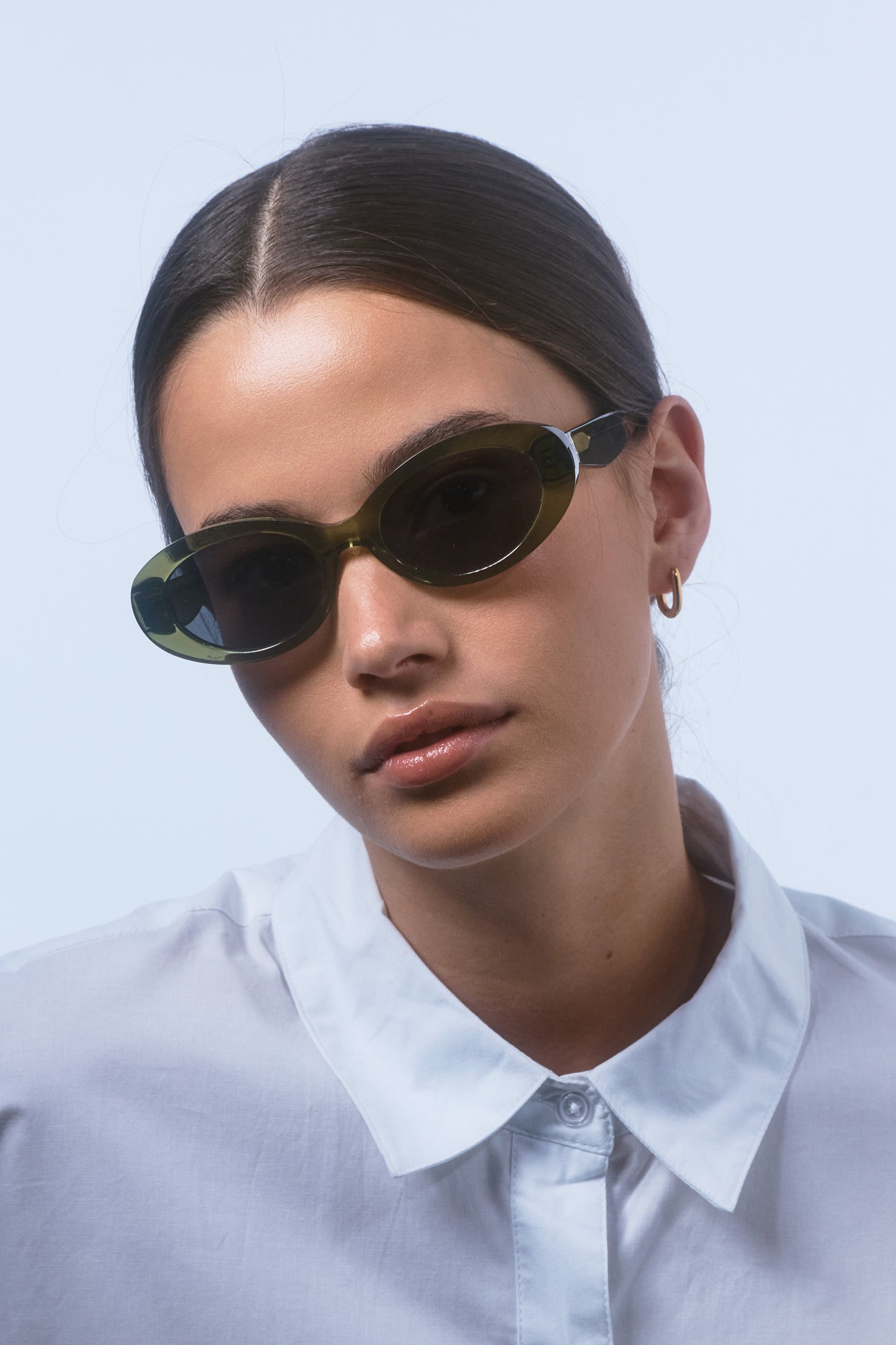 Female model wearing Isle of Eden Frankie frosted green sunglasses, front-facing portrait looking directly at the camera