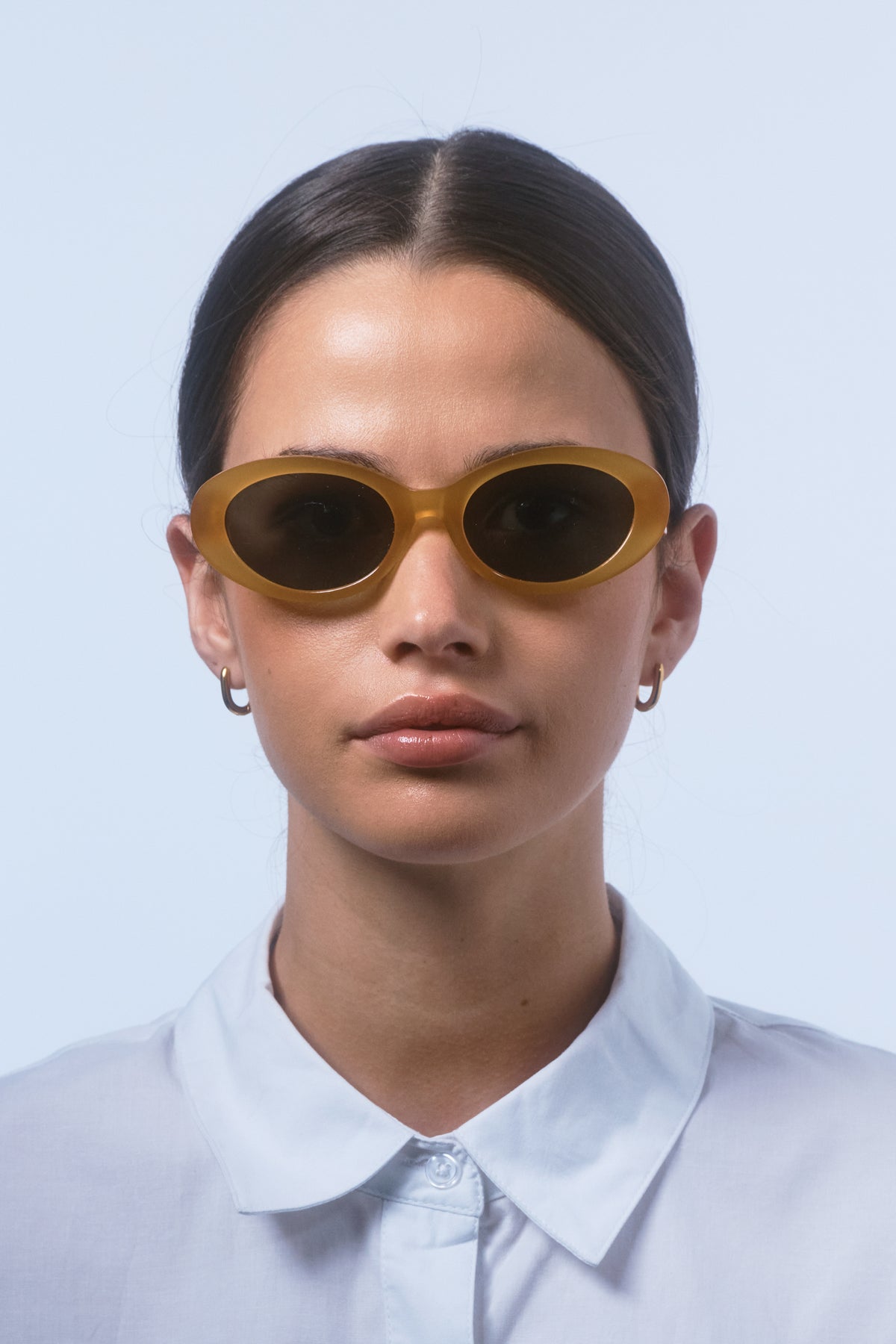 Female model wearing Isle of Eden Frankie yellow sunglasses, front-facing portrait looking directly at the camera