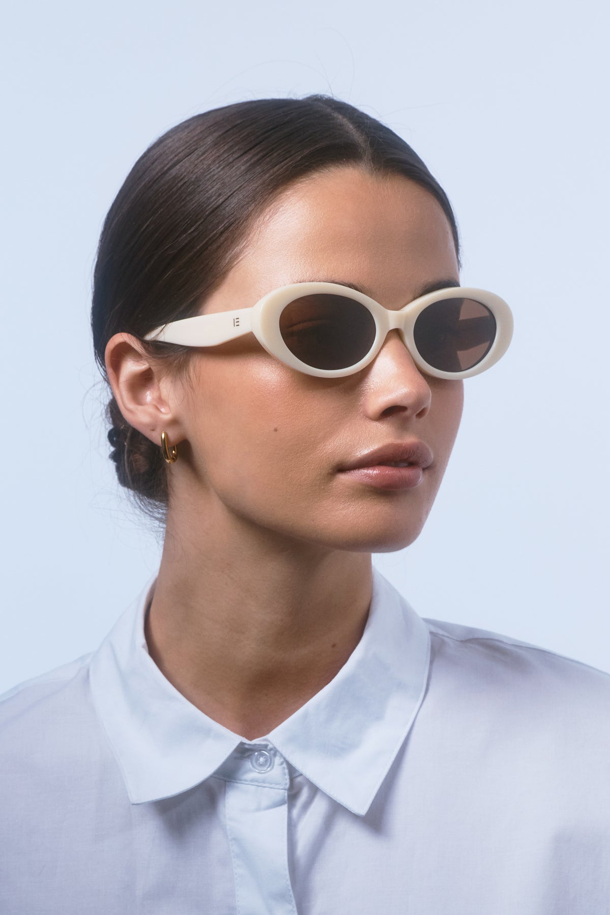Female model wearing Isle of Eden Frankie ivory sunglasses, front-facing portrait looking directly at the camera