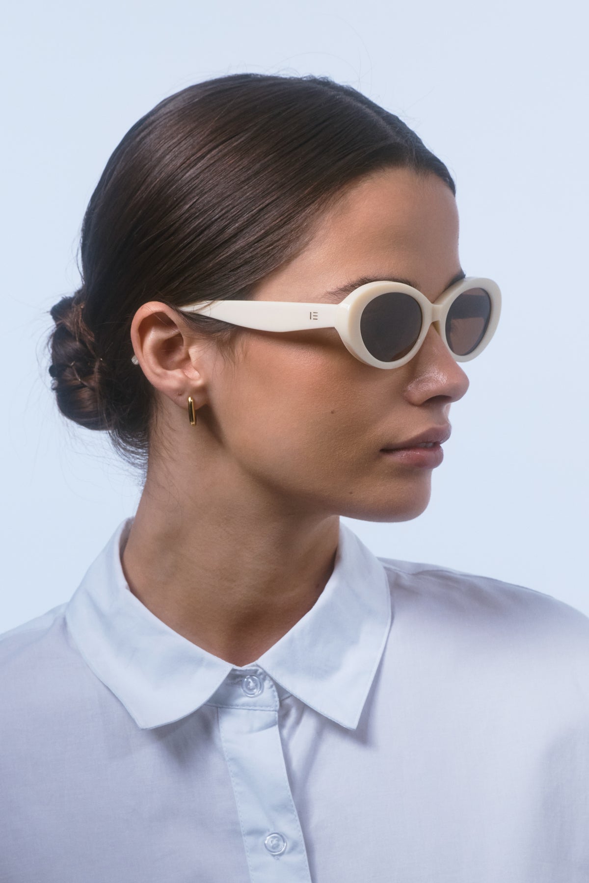 Female model wearing Isle of Eden Frankie ivory sunglasses, side profile portrait