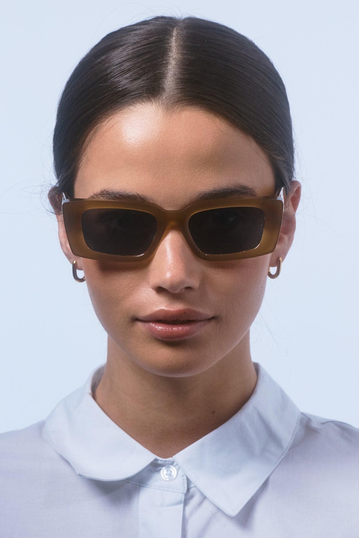 Female model wearing Isle of Eden Goldie dijon sunglasses, front-facing portrait looking directly at the camera