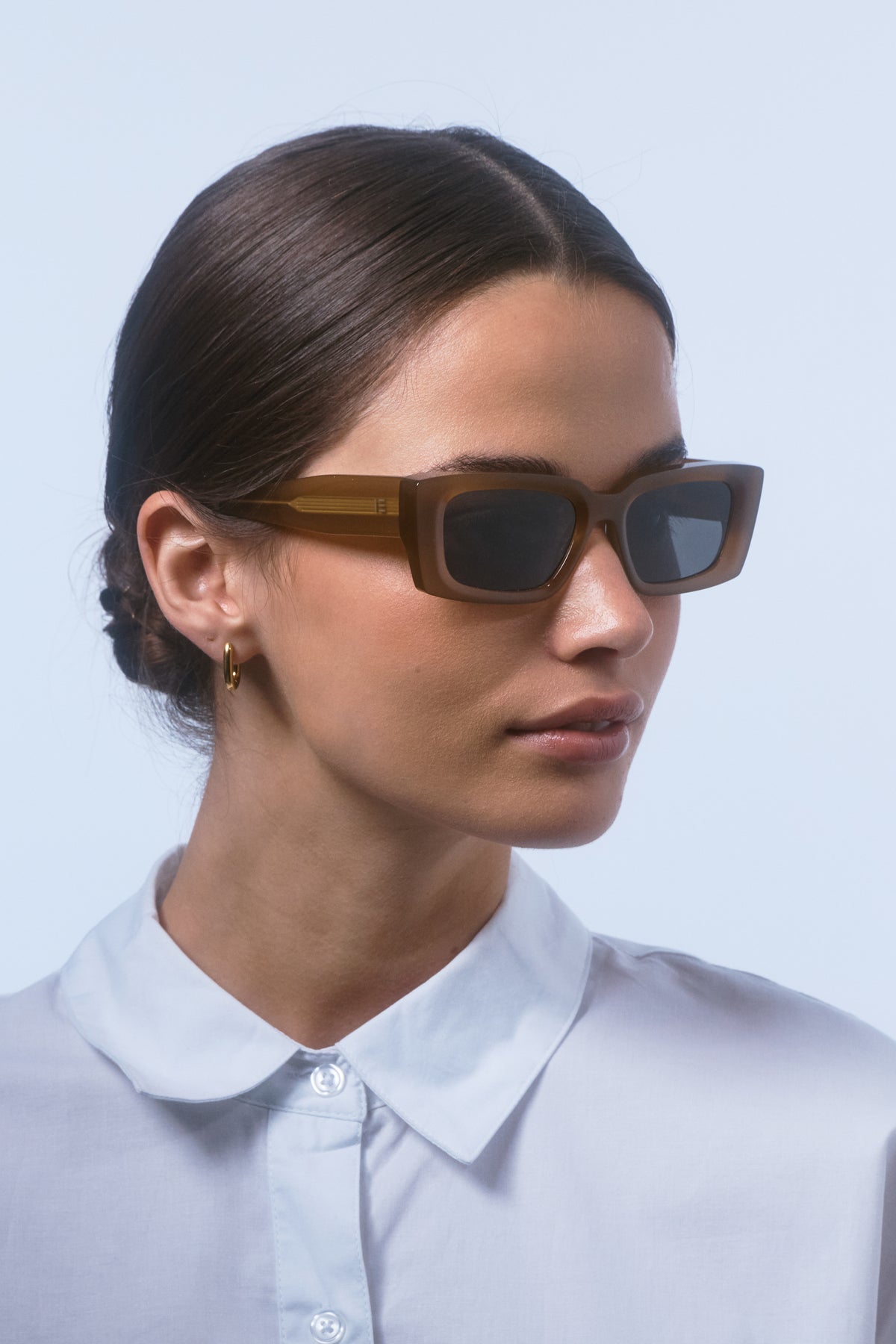 Female model wearing Isle of Eden Goldie dijon sunglasses, angled portrait looking away