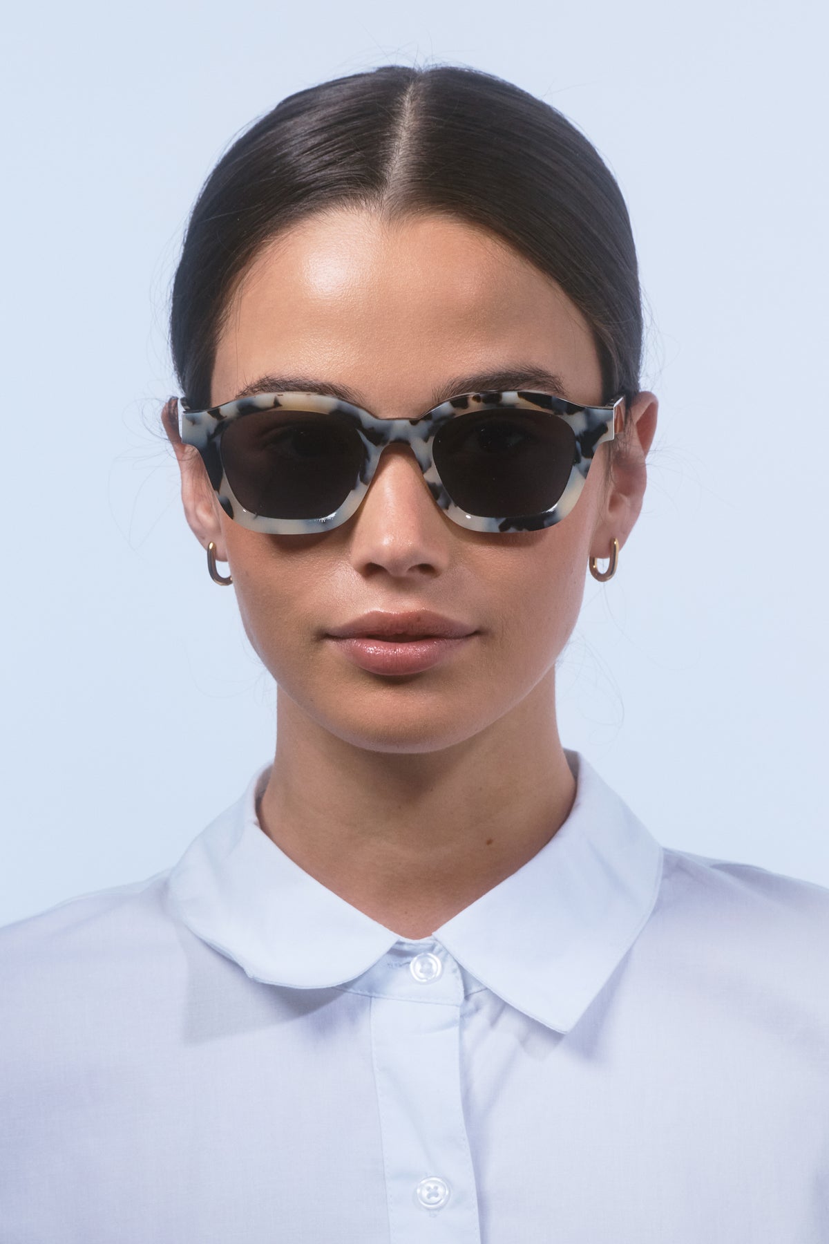 Female model wearing Isle of Eden Harley white tortoise sunglasses, front-facing portrait looking directly at the camera