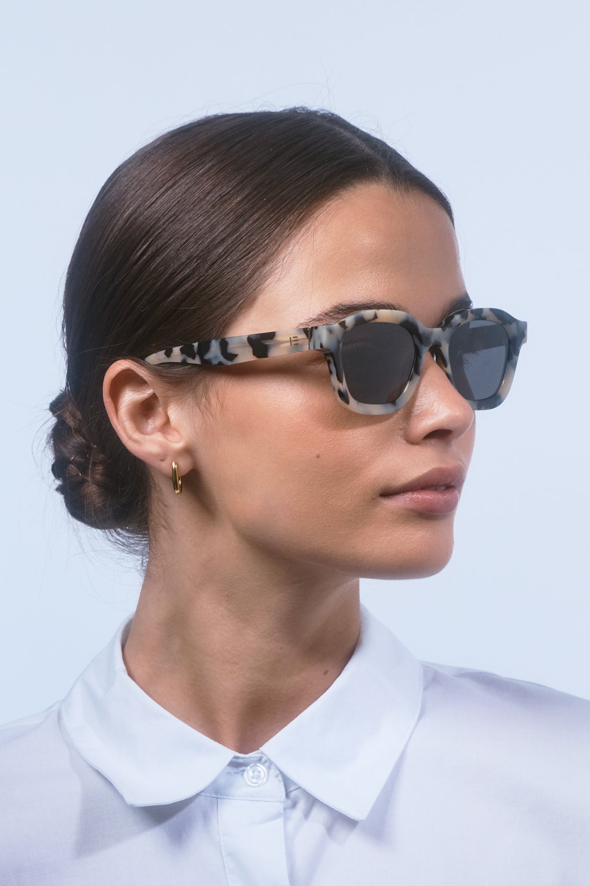 Female model wearing Isle of Eden Harley white tortoise sunglasses, side profile portrait