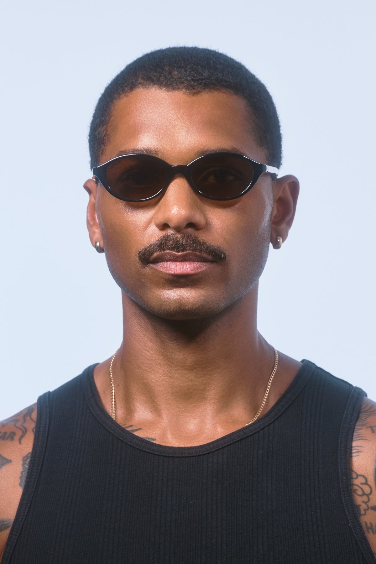 Male model wearing Isle of Eden Mirabel black sunglasses, front-facing portrait looking directly at the camera