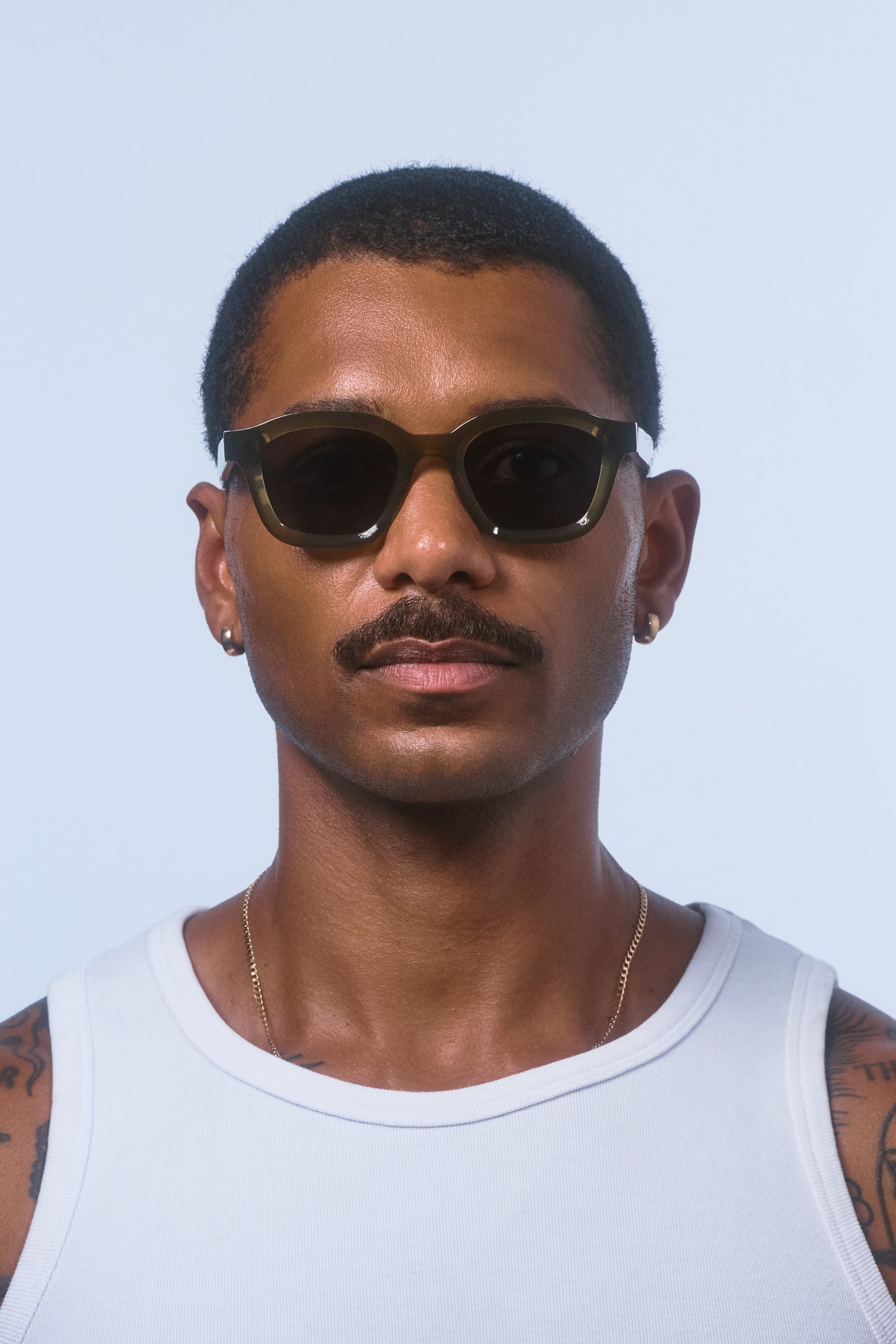 Male model wearing Isle of Eden Harley frosted green sunglasses, front-facing portrait looking directly at the camera