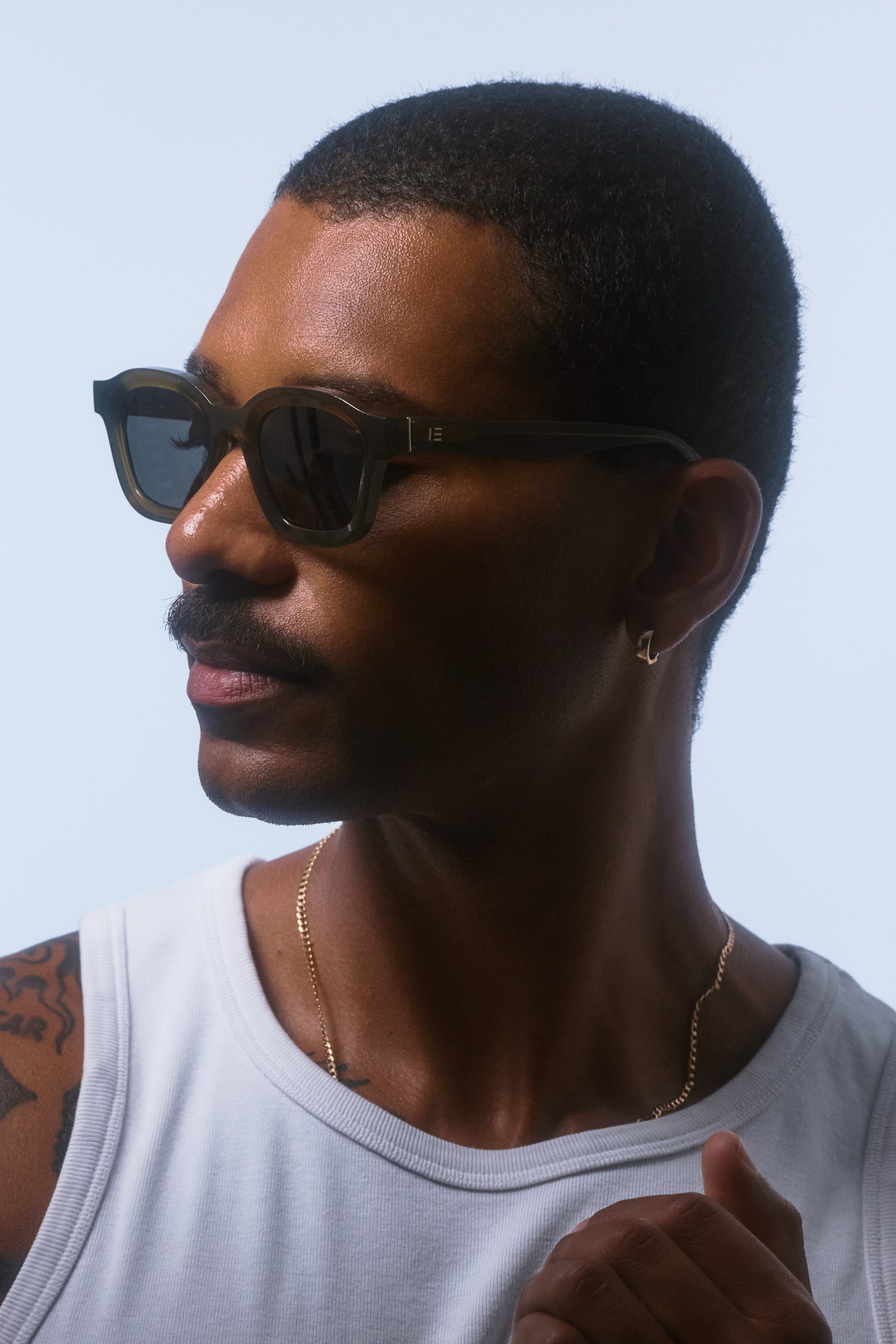 Male model wearing Isle of Eden Harley frosted green sunglasses, angled portrait
