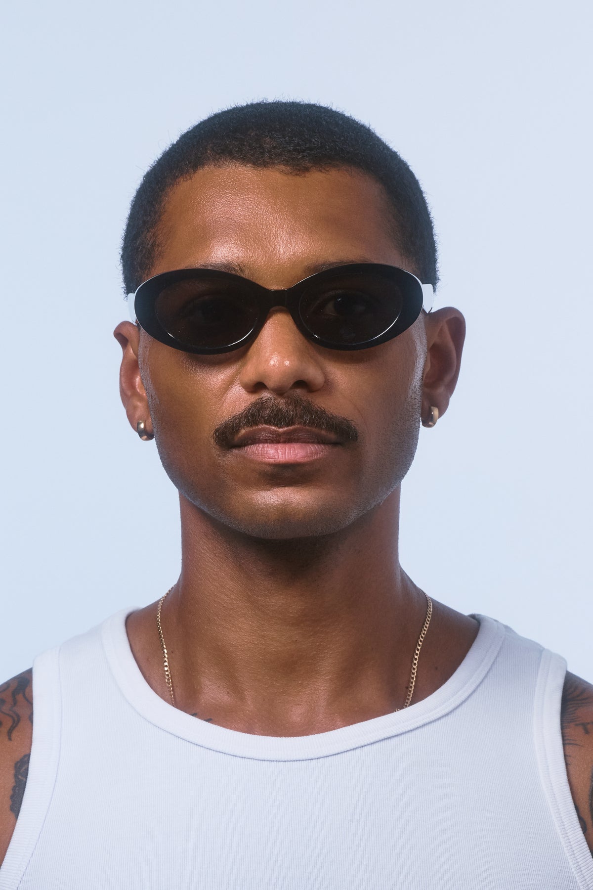 Male model wearing Isle of Eden Frankie black sunglasses, front-facing portrait looking directly at the camera
