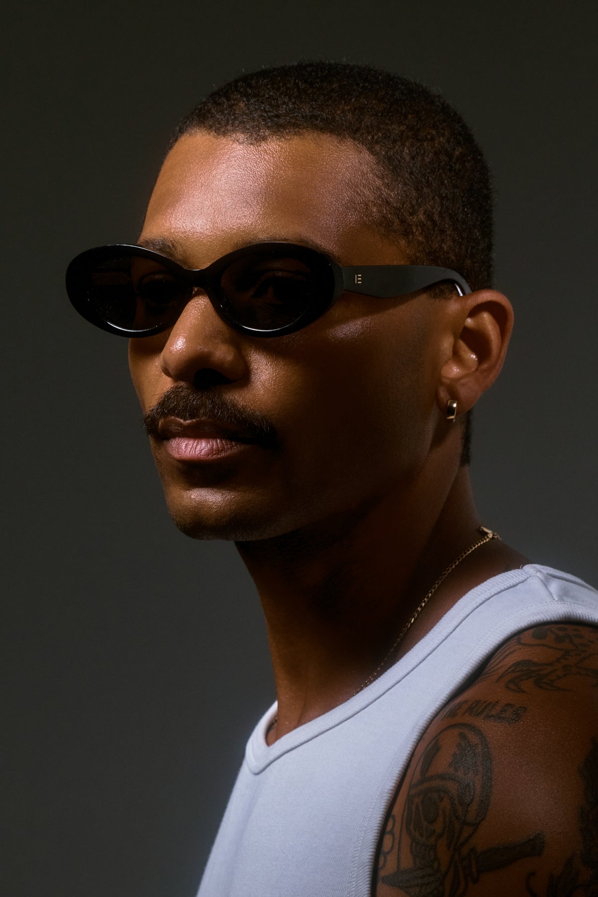 Male model wearing Isle of Eden Frankie black sunglasses, side profile portrait