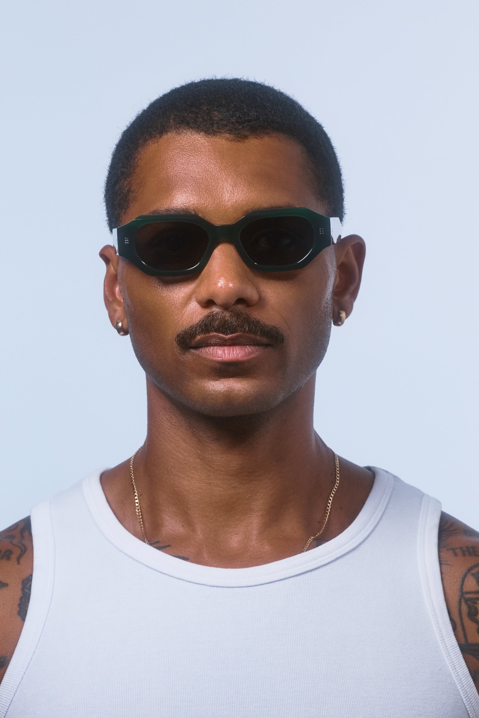 Male model wearing Isle of Eden Blake emerald sunglasses, front-facing portrait showing hexagonal frame fit