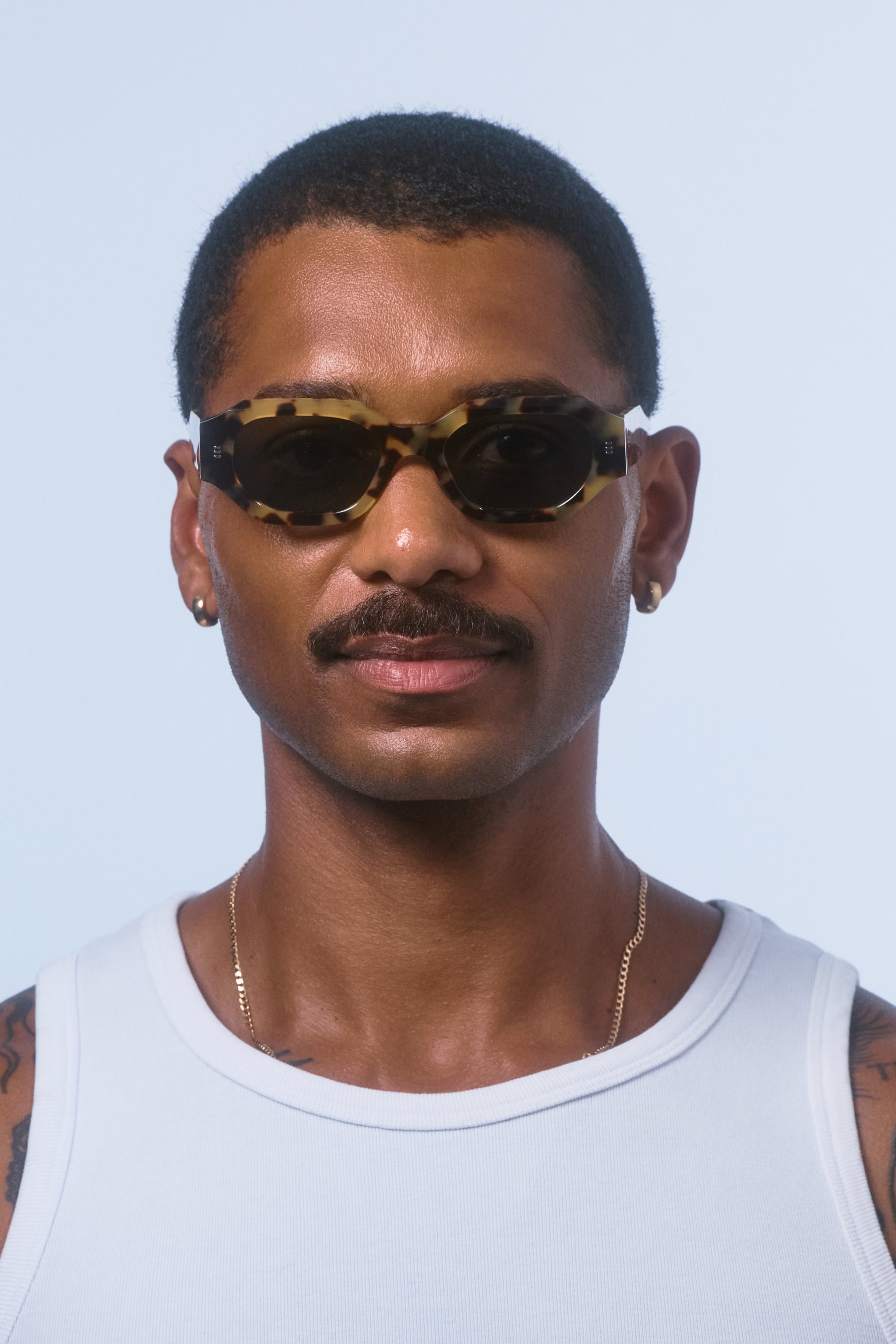 Male model wearing Isle of Eden Blake tortoise sunglasses, front-facing portrait showing hexagonal frame fit