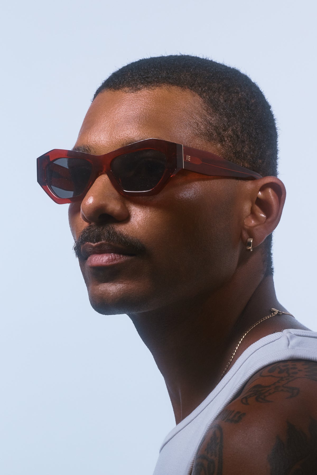 Male model wearing Isle of Eden Emily red sunglasses, side profile portrait
