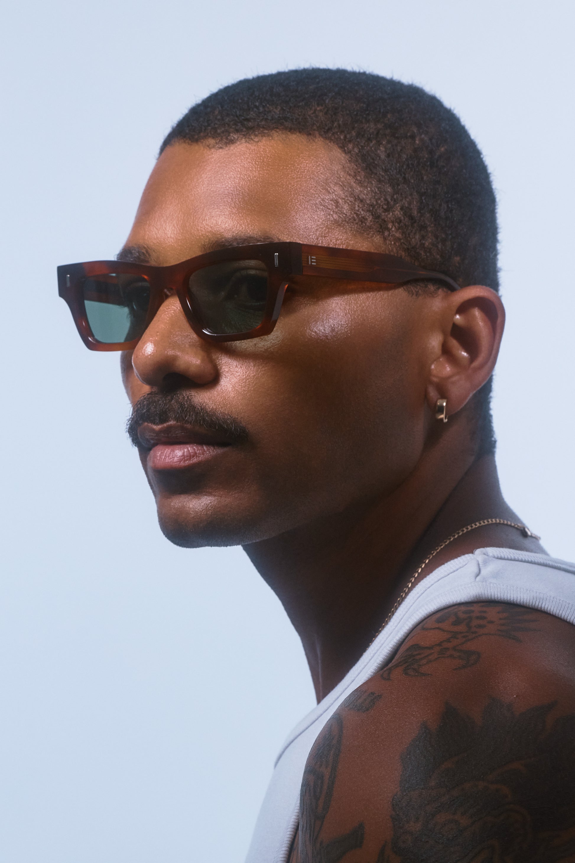 Male model wearing Isle of Eden Olli honey tortoise sunglasses, side profile portrait