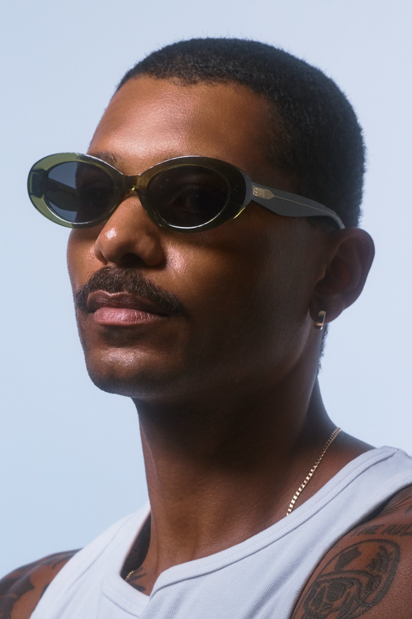 Male model wearing Isle of Eden Frankie frosted green sunglasses, angled portrait looking away