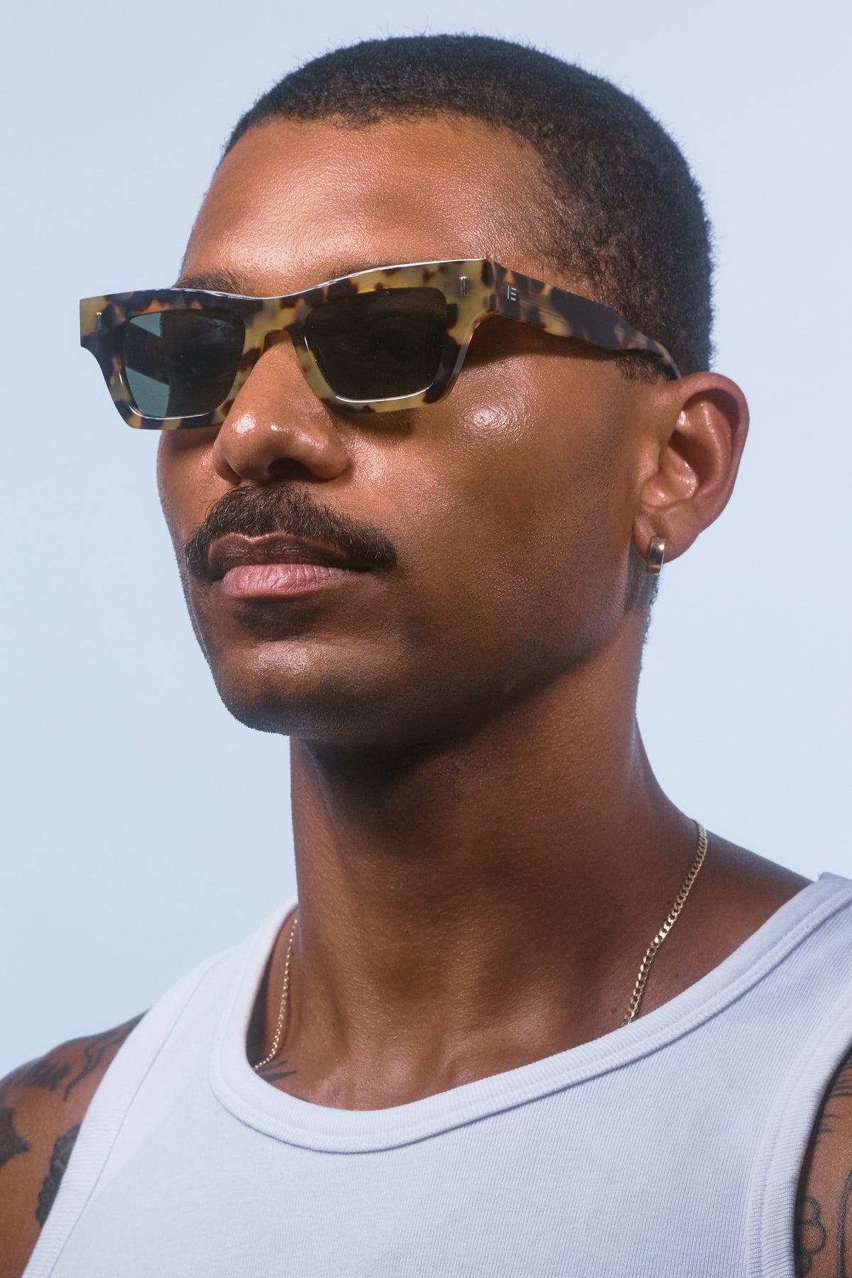 Male model wearing Isle of Eden Olli tortoise sunglasses, angled portrait looking away