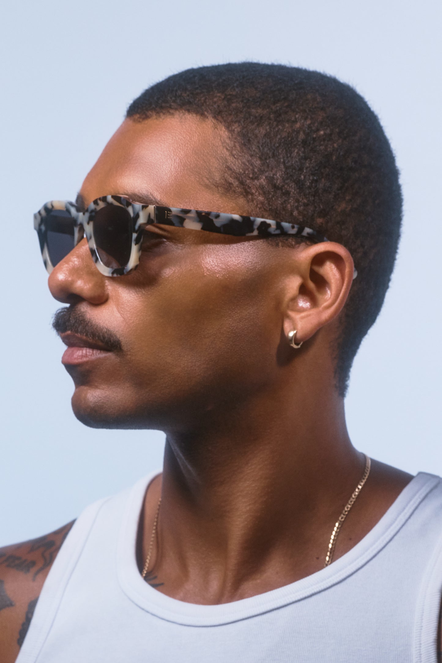 Male model wearing Isle of Eden Harley white tortoise sunglasses, angled portrait looking away